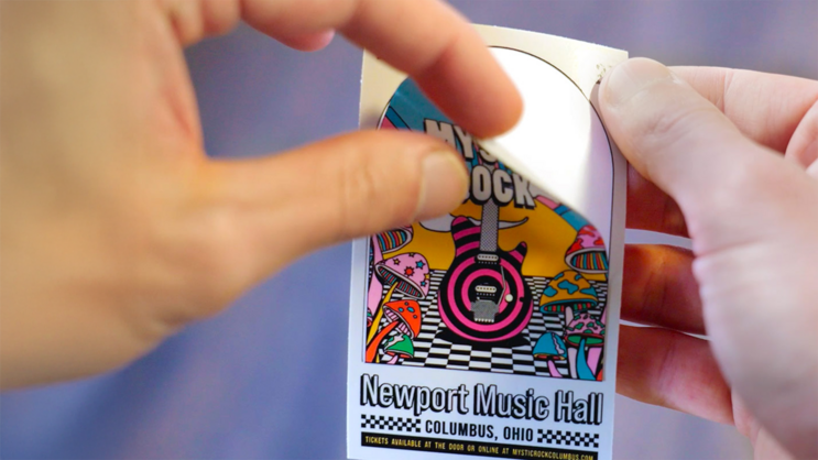 Someone peeling a kiss cut sticker from the backing